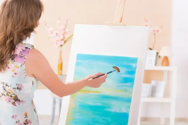 A woman working on a painting.